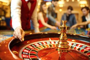 El croupier sostiene en la mano una bola de ruleta en un casino. Juegos de azar en un casino.